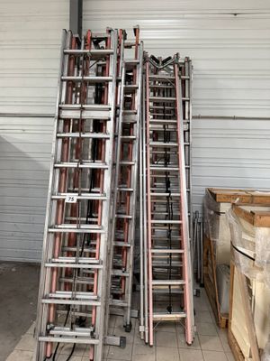many ladders stacked up in a warehouse area