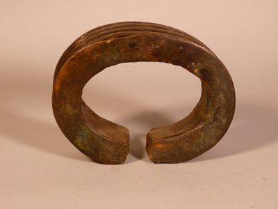 an image of a bronze bracelet with a curved design on it