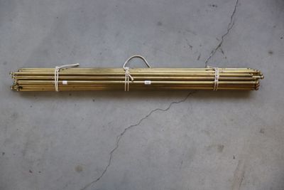 a pair of brass tubes tied together on a concrete surface