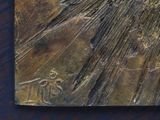 a metal plaque with a bird on it on a table