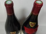 two bottles of wine sitting on top of a counter next to each other