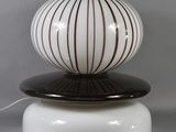 a lamp that is on top of a white base