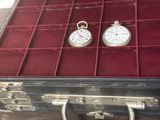 deux montres de poche en argent rangées dans un écrin rouge