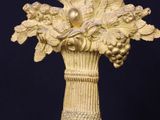 a gold vase with a bunch of flowers on top of it