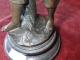 a bronze statue of a boy holding a bird