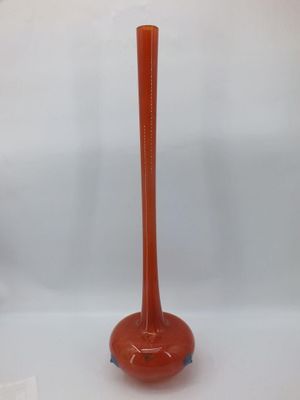 an orange vase sitting on top of a table next to a white wall