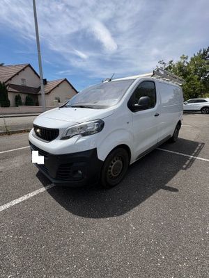 the white van is parked in the parking lot near a house