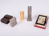 plusieurs types différents de briquets et d'étuis à briquets posés sur une surface blanche