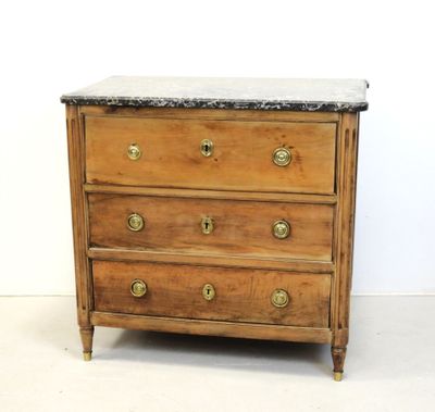 une commode ancienne avec dessus en marbre et poignées en laiton