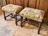 two stools that are sitting in front of a cabinet