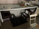 une petite cuisine avec un plan de travail en verre et des tabourets