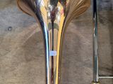 a brass trumpet sitting next to a ladder in a room
