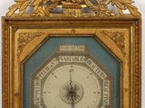 une horloge dorée accrochée au mur, avec un cadre bleu