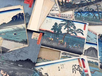 a pile of old japanese paintings on a table