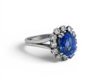 an oval blue sapphire and diamond ring on a white background