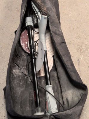 un sac noir posé par terre, contenant des outils
