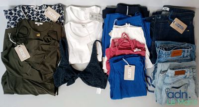 Plusieurs paires de jeans sont disposées sur une surface blanche