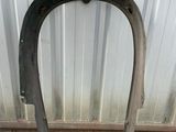 the front fender of a motorcycle is shown against a metal wall