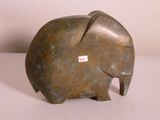 une statue d'éléphant posée sur une table, avec un autocollant sur le dos