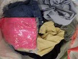 un tas de vêtements dans un sac en plastique posé sur un lit