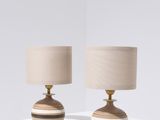 deux lampes en bois posées sur une table blanche, avec un abat-jour beige