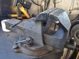 an old vise on a workbench in a workshop