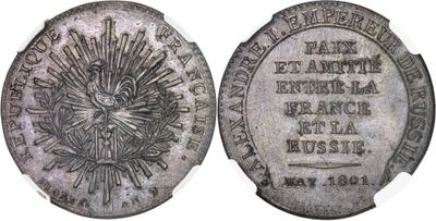a close up of a silver coin with a sun on it
