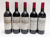 quatre bouteilles de vin sont alignées sur une surface blanche