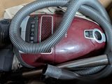 un aspirateur rouge qui se trouve à l'intérieur d'une boîte
