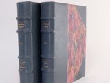 two books sitting on top of each other on a white surface