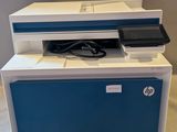 une imprimante bleue et blanche posée sur une table blanche