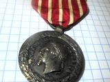 une image représentant une médaille entourée d'un ruban rouge