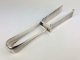 a silver metal tonget with a handle on a white surface