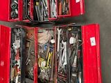 deux boîtes rouges posées par terre, contenant des outils