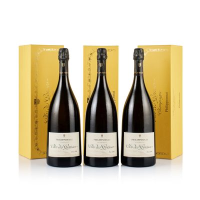 three bottles of champagne in front of a yellow box