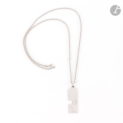 gros plan d'un collier sur une surface blanche avec une chaîne