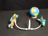 a toy airplane and a toy earth on a black surface