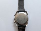 the watch is sitting on a white surface with a black strap