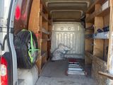 the back of a van with the door open and a tire in the back