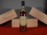 une bouteille de vin posée sur une table, à côté de deux caisses en bois
