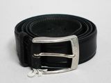 une ceinture noire ornée d'une boucle argentée sur un fond blanc