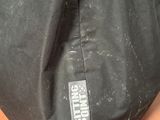 the back of a black bag sitting on top of a wooden floor