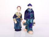 two figurines of a man and a woman standing next to each other