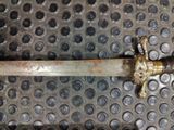 a metal pipe with a brass handle on a metal surface