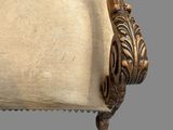 an old chair with a beige upholstered seat and a wooden frame