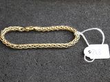 a close up of a gold bracelet with a tag on it