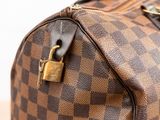 a brown and black checkered bag with a lock on it