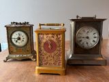 trois petites horloges posées côte à côte sur une table