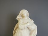 une statue de femme tenant un bébé dans ses bras