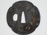 une tsuba en fer noir ornée de fleurs